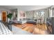 Bright living room with a comfortable gray sofa, wood floors, and large windows at 12653 Rancho Ct, Conifer, CO 80433