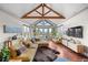 Bright living room featuring hardwood floors, a wooden ceiling beam, mountain views, and cozy furniture at 12653 Rancho Ct, Conifer, CO 80433