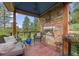 Cozy outdoor area with a stone fireplace, comfortable seating, and scenic views at 12653 Rancho Ct, Conifer, CO 80433