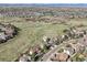 Aerial view of a home surrounded by a green neighborhood, mountains, and a blue sky at 9977 Falcon Creek Dr, Highlands Ranch, CO 80130