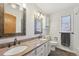Bathroom featuring a double sink vanity, framed mirrors, and stylish fixtures at 9977 Falcon Creek Dr, Highlands Ranch, CO 80130