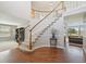 Bright entryway featuring hardwood floors, a curved staircase, and natural light at 9977 Falcon Creek Dr, Highlands Ranch, CO 80130