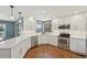Stylish kitchen featuring white cabinets, stainless steel appliances and hardwood floors at 9977 Falcon Creek Dr, Highlands Ranch, CO 80130