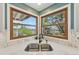 Corner kitchen sink with stainless-steel faucet and bright windows highlighting lush outdoor views at 9977 Falcon Creek Dr, Highlands Ranch, CO 80130