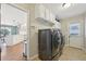 Functional laundry room with washer, dryer, cabinets and access to kitchen and backyard at 9977 Falcon Creek Dr, Highlands Ranch, CO 80130