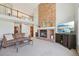 Bright living room with tall ceilings, a brick fireplace and a large television at 9977 Falcon Creek Dr, Highlands Ranch, CO 80130