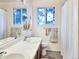 Well-lit bathroom features a double sink, vanity, mirror, and a window bringing in natural light and bright white walls at 29983 Hilltop Dr # 2, Evergreen, CO 80439