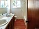 Bathroom with double sinks, vanity, light wooden floors, and a window to bring in natural light at 29983 Hilltop Dr # 2, Evergreen, CO 80439