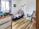 Bright bedroom filled with lots of toys, a single bed, storage units, and light-colored wood floors at 29983 Hilltop Dr # 2, Evergreen, CO 80439