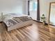 Bright bedroom with a light wooden floor, monstera plant, light bed frame, and a sun-filled window view at 29983 Hilltop Dr # 2, Evergreen, CO 80439