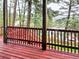 Red painted deck offering a relaxing view of surrounding trees and nature, perfect for outdoor enjoyment at 29983 Hilltop Dr # 2, Evergreen, CO 80439