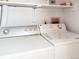 Bright laundry room with newer washer and dryer, overhead shelving, and ample natural light for convenience at 29983 Hilltop Dr # 2, Evergreen, CO 80439