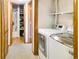Modern laundry room featuring a washer, dryer, shelving, and a storage room or closet for optimal organization at 29983 Hilltop Dr # 2, Evergreen, CO 80439