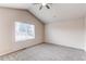 A bedroom with neutral walls and carpet and a window looking out to the fenced yard at 468 English Sparrow Trl, Highlands Ranch, CO 80129