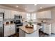Well-lit kitchen with stainless steel appliances, white cabinets, and central island with seating at 468 English Sparrow Trl, Highlands Ranch, CO 80129