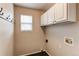 Convenient laundry room featuring white cabinets and hook rack, providing ample storage space at 468 English Sparrow Trl, Highlands Ranch, CO 80129