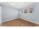 Neutral bedroom with vinyl flooring and a three-window view at 5031 Upton Ct, Denver, CO 80239