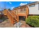 Wooden deck with stairs leading down to the grassy backyard at 5031 Upton Ct, Denver, CO 80239