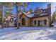 Stunning two-story home with stone accents and snowy landscape at 590 Cumberland Rd, Larkspur, CO 80118