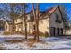 Two-car garage and side view of house in snowy setting at 590 Cumberland Rd, Larkspur, CO 80118