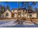 Back of house with stucco and stone exterior, and a snowy yard at 590 Cumberland Rd, Larkspur, CO 80118