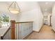 Upstairs hallway with wooden railing and carpet at 590 Cumberland Rd, Larkspur, CO 80118