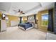 Spacious bedroom with large bed, fan, carpet and two windows allowing for natural light and plenty of space at 5238 Gould Cir, Castle Rock, CO 80109