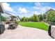Back patio with a well-manicured backyard, outdoor seating, and a built-in grill at 5238 Gould Cir, Castle Rock, CO 80109
