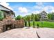 Back patio with a built-in stone fireplace and a well-manicured backyard at 5238 Gould Cir, Castle Rock, CO 80109