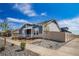 Attractive home featuring a blue and gray exterior, stone accents, manicured front yard and a vinyl fence at 5150 N Quemoy Ct, Aurora, CO 80019