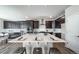 Spacious kitchen featuring dark cabinets, stainless steel appliances, an island with white countertop, and barstool seating at 5150 N Quemoy Ct, Aurora, CO 80019