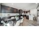 Spacious kitchen and dining area featuring dark cabinets, stainless steel appliances, and modern finishes at 5150 N Quemoy Ct, Aurora, CO 80019