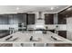 Modern kitchen with dark cabinets, stainless steel appliances, an island with white countertop, and barstool seating at 5150 N Quemoy Ct, Aurora, CO 80019