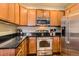 Modern kitchen with stainless steel appliances, sleek black countertops and light wood cabinets at 9019 E Panorama Cir # D207, Englewood, CO 80112