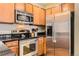 Modern kitchen featuring stainless steel appliances, sleek black countertops and light wood cabinets at 9019 E Panorama Cir # D207, Englewood, CO 80112