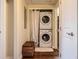 Laundry room with stacked washer and dryer and storage bench at 9019 E Panorama Cir # D207, Englewood, CO 80112