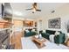 Bright living room featuring stylish green sofas, a ceiling fan, and wood flooring at 9019 E Panorama Cir # D207, Englewood, CO 80112