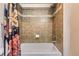 Shower features chrome shower head, brown tiling, and floral shower curtain at 9019 E Panorama Cir # D207, Englewood, CO 80112