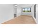 Bright bedroom featuring hardwood floors, modern lighting, and an ensuite bathroom entrance at 1601 Park Ave # 307, Denver, CO 80218