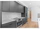 Modern kitchen features stainless steel appliances and sleek gray cabinetry at 1601 Park Ave # 307, Denver, CO 80218