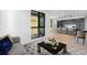 Living room with hardwood floors, large windows, and modern decor with view into the kitchen at 1601 Park Ave # 307, Denver, CO 80218