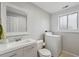 Utility bathroom with light grey paint, mirror, sink and vanity, toilet, and a washer at 9683 Josephine Pl, Thornton, CO 80229