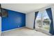 Bedroom featuring a navy accent wall and a large window showcasing the neighborhood at 9683 Josephine Pl, Thornton, CO 80229