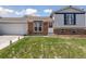 Charming split-level home featuring a well-manicured lawn, brick accents, and a spacious two-car garage at 9683 Josephine Pl, Thornton, CO 80229