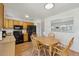 This eat-in kitchen features wood cabinets, black appliances and a large pass through window at 9683 Josephine Pl, Thornton, CO 80229