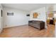 Cozy living room featuring wood-look floors, neutral decor, and view into kitchen at 9683 Josephine Pl, Thornton, CO 80229