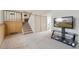 Spacious living room with wood paneled accent wall, staircase and large TV at 9683 Josephine Pl, Thornton, CO 80229