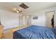 Spacious main bedroom with a blue quilt on the bed, wood details, carpet and multiple doors at 9683 Josephine Pl, Thornton, CO 80229