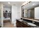 Bathroom with double sinks, a large mirror, and walk-in closet at 891 14Th St # 3415, Denver, CO 80202