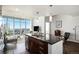 Modern kitchen island with dark countertops and seating, open to a living area with expansive city views at 891 14Th St # 3415, Denver, CO 80202